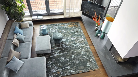 Külmades toonides villane vaip ja sametine diivan mõjuvad kokkuvõttes siiski soojalt. 