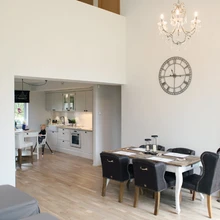 Taaskasutuspuidust, romantilise joonega söögilauakomplekt muudab uue eramu napi arhiteltuuri hubasemaks. Tumedate toolide kontrast tõstab seda ülejäänud ruumist veelgi enam esile.